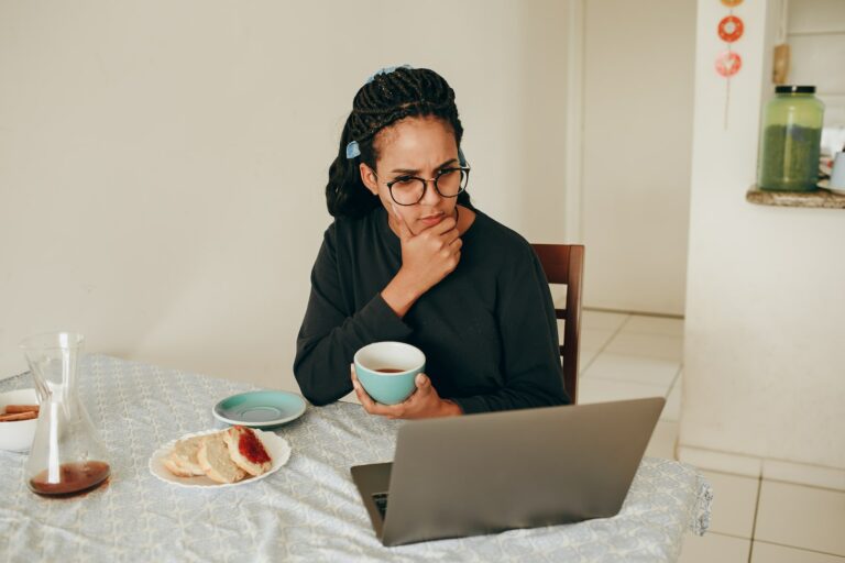 A woman considering what she sees on her laptop